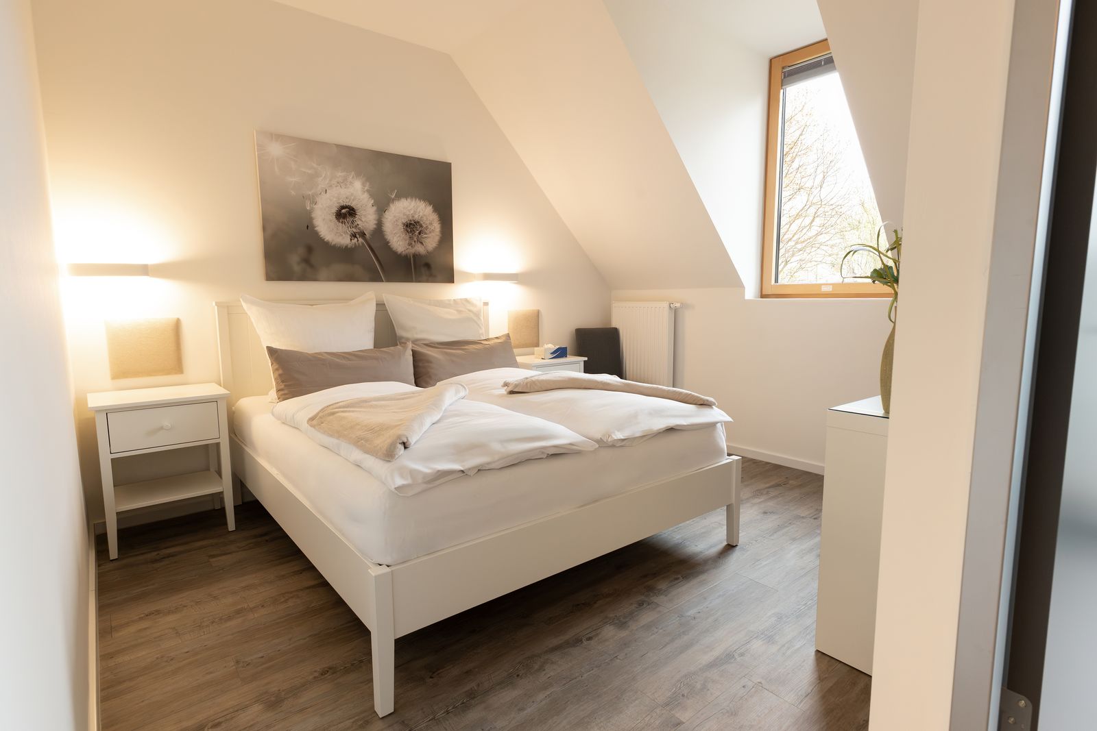 Doppelzimmer Pusteblume mit weißem Holzbett, Wandleuchten und Fenster